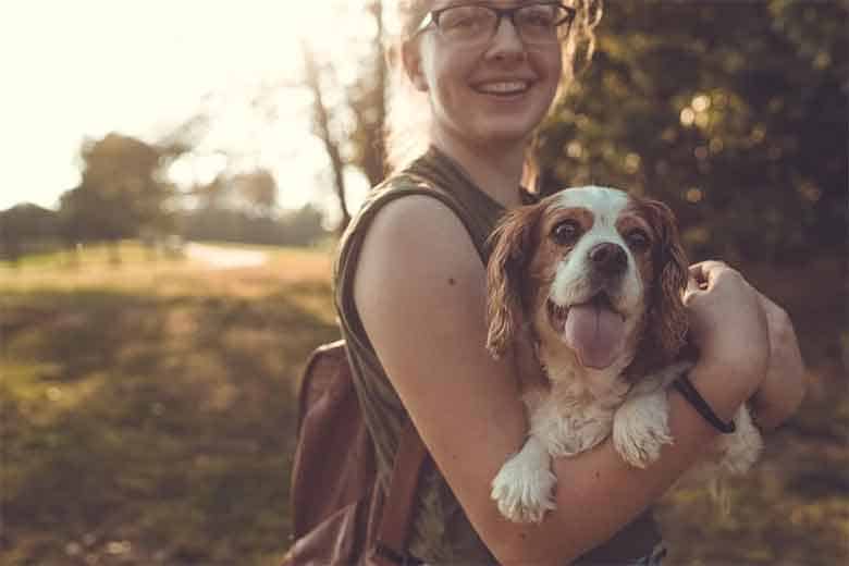 une jeune femme porte son chien parce qu'il fait trop chaud